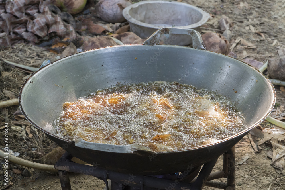 Vegetable oil is boiling in a steel pan. Vegetable oil is boiling in a steel pan.