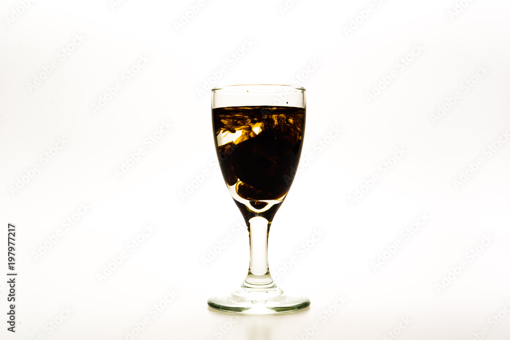 Brown / Chocolate food coloring diffuse in water inside wine glass with empty copy-space area for slogan or advertising text message, over isolated white background. Brown / Chocolate food coloring diffuse in water inside wine glass with empty copy-space area for slogan or advertising text message, over isolated white background.