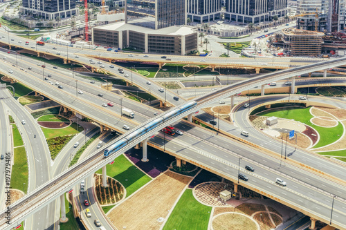 Aerial view of big highway interchange with traffic in Dubai, UAE, at day. Scenic cityscape. Colorful transportation, communications and driving background.