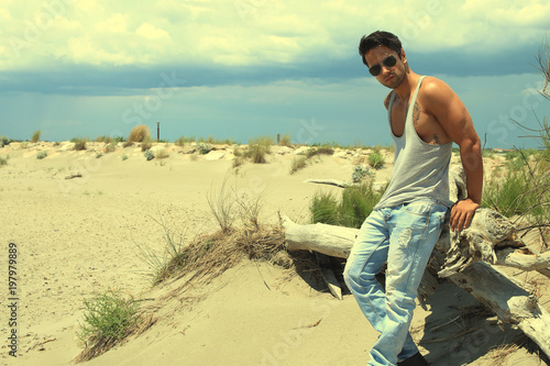 Bel homme musclé posant sur la plage  photo