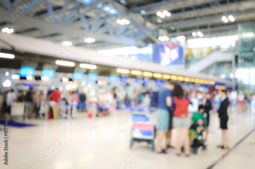 Blurred image of airport check-in counters with passengers and crowd of people control barriers with bokeh in international airport, que, travel, tourism, business concept Abstract Blur Background. © narin_nonthamand