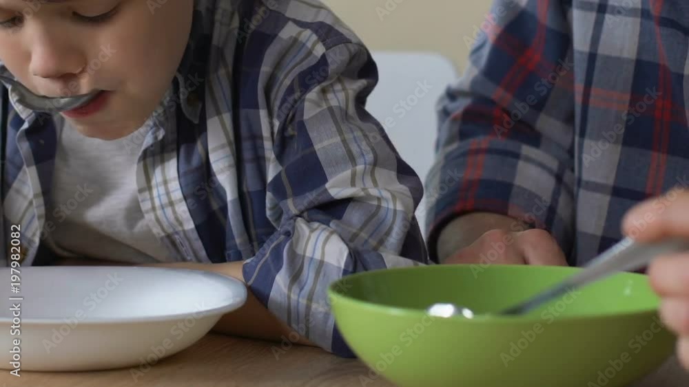 Son and single father having poor breakfast together, malnutrition, close up Son and single father having poor breakfast together, malnutrition, close up