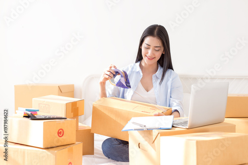 Young asian woman business owner work and white down address for deliver at home, woman business owner concept, 20-25 year old.