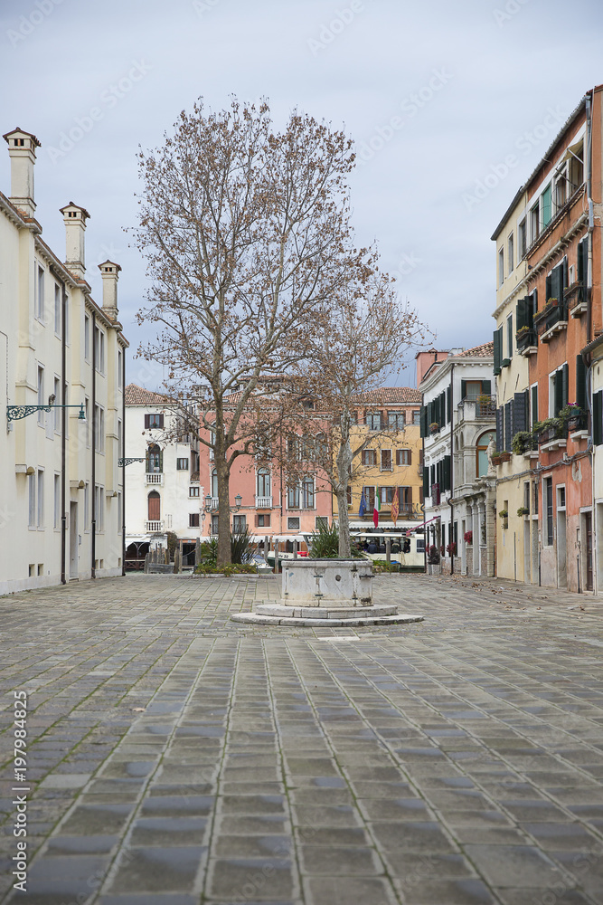 Typical small square in Venice old town with an old well and coble stone ground, Venice , Italy