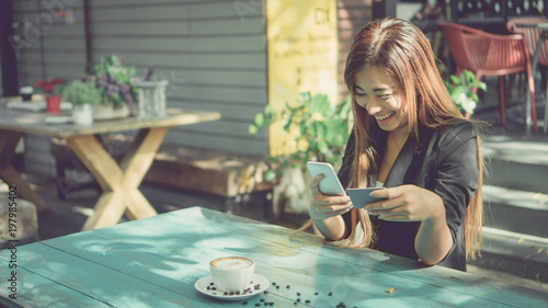 Businessman holding a card or business card. To do business through the phone in the coffee shop. selected focus, coffee break, relaxation, Vintage style.