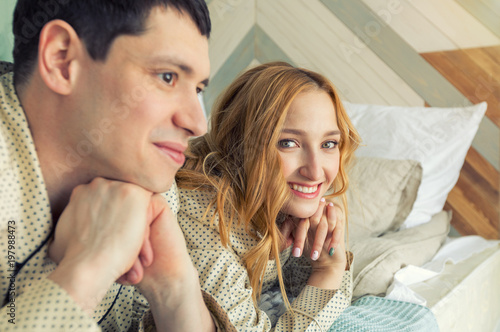 Happy young couple in pajamas early in the morning in her apartment. Family life. photo