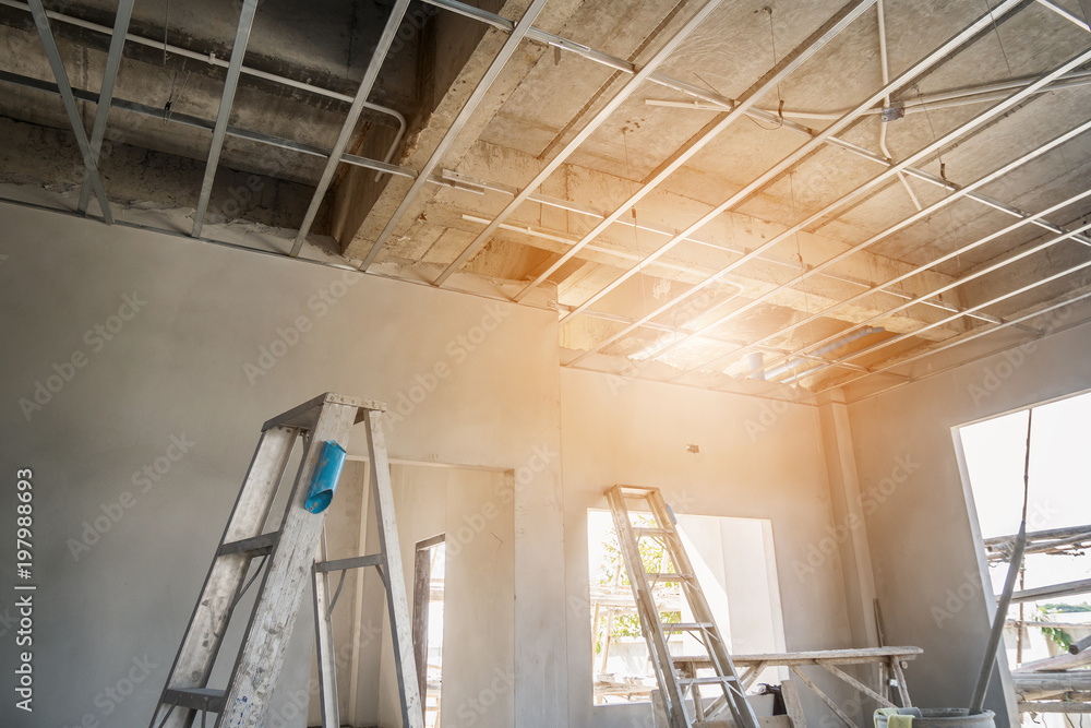 Obraz premium Install metal frame for plaster board ceiling at house under construction