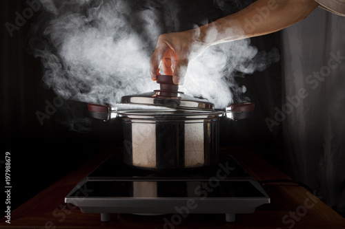 hand holding of metal pot cover with hot steam flowing from inside