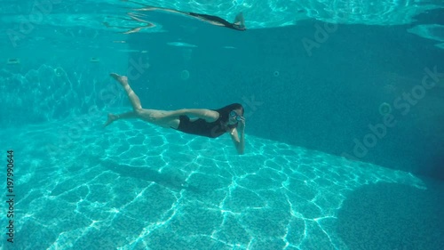 woman with long hair dives into the pool