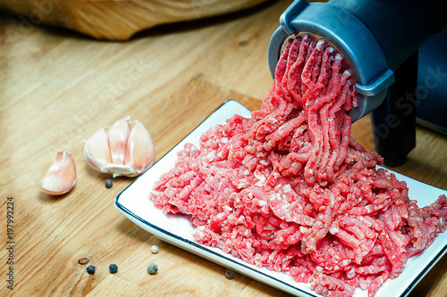 Minced meat coming out from grinder. Healthy homemade minced meat.  Horizontal view photo. Place for copyspace. photo