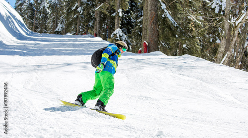 Photo of man riding snowboard from snowy hill