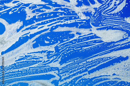 Washing windows in the house. Glass in foam against blue sky background