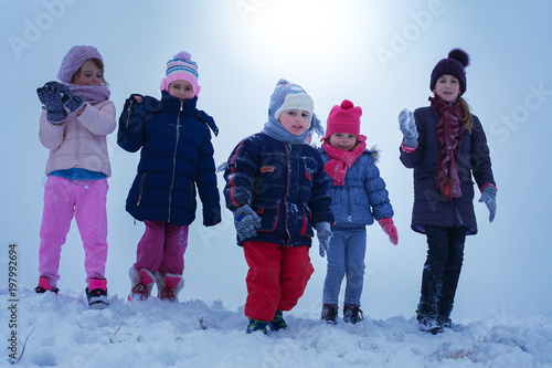  Medium group of  children standing in the snow.