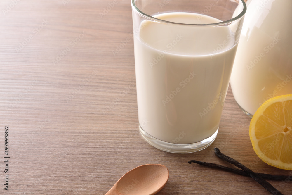Glass of milk on wooden table lemons and cinnamon closeup Glass of milk on wooden table lemons and cinnamon closeup
