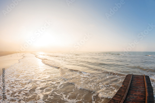 Wooden pier. Beach of Lido di Jesolo at adriatic Sea in a beautiful summer day Italy. near Venice. dense sea breeze at dawn