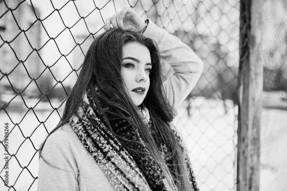 Close up portrait of brunette girl in scarf against cage. Close up portrait of brunette girl in scarf against cage.