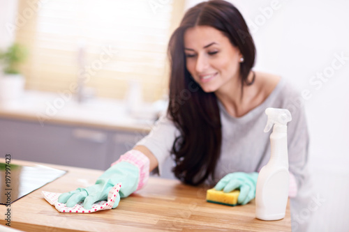 Beautiful young woman cleaning the kitchen