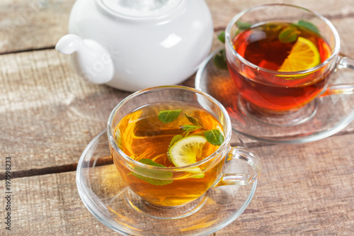 cup of black tea with mint leaves on a wooden table