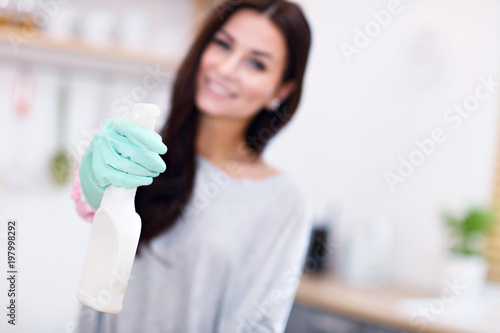 Beautiful young woman cleaning the kitchen