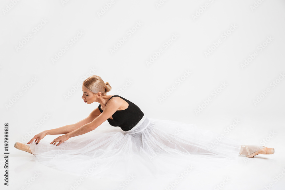 Amazing woman ballerina sitting stretching gracefully