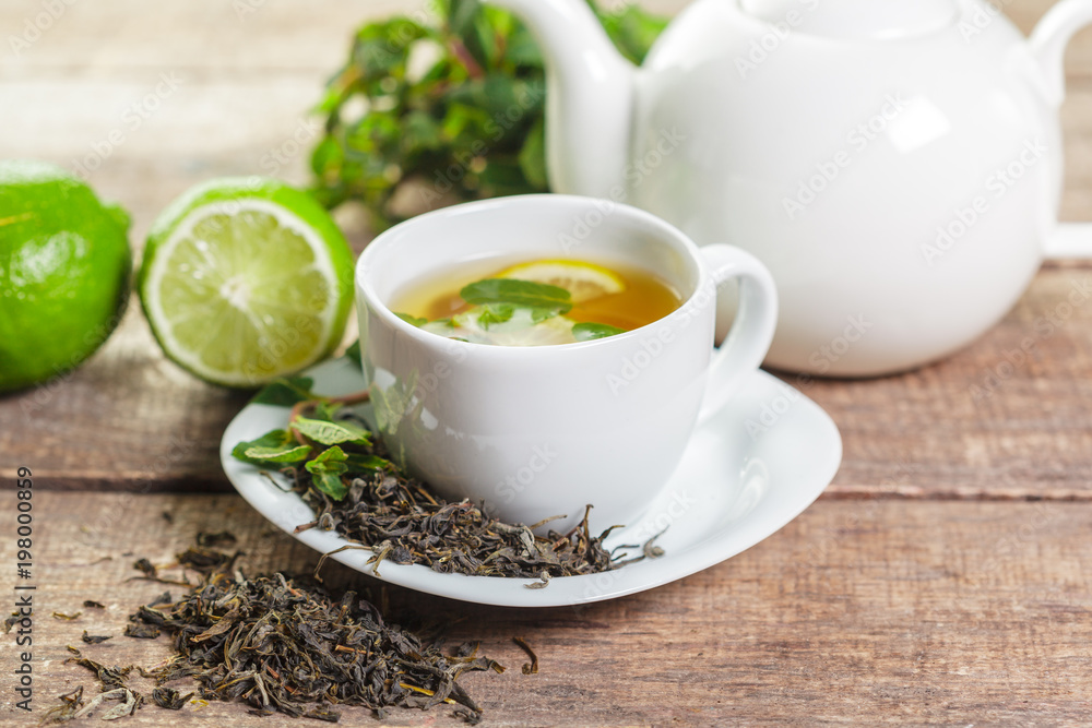 cup of black tea with mint leaves on a wooden table