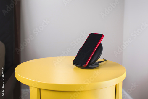 Smartphone is placed on a wireless fast charger station photo