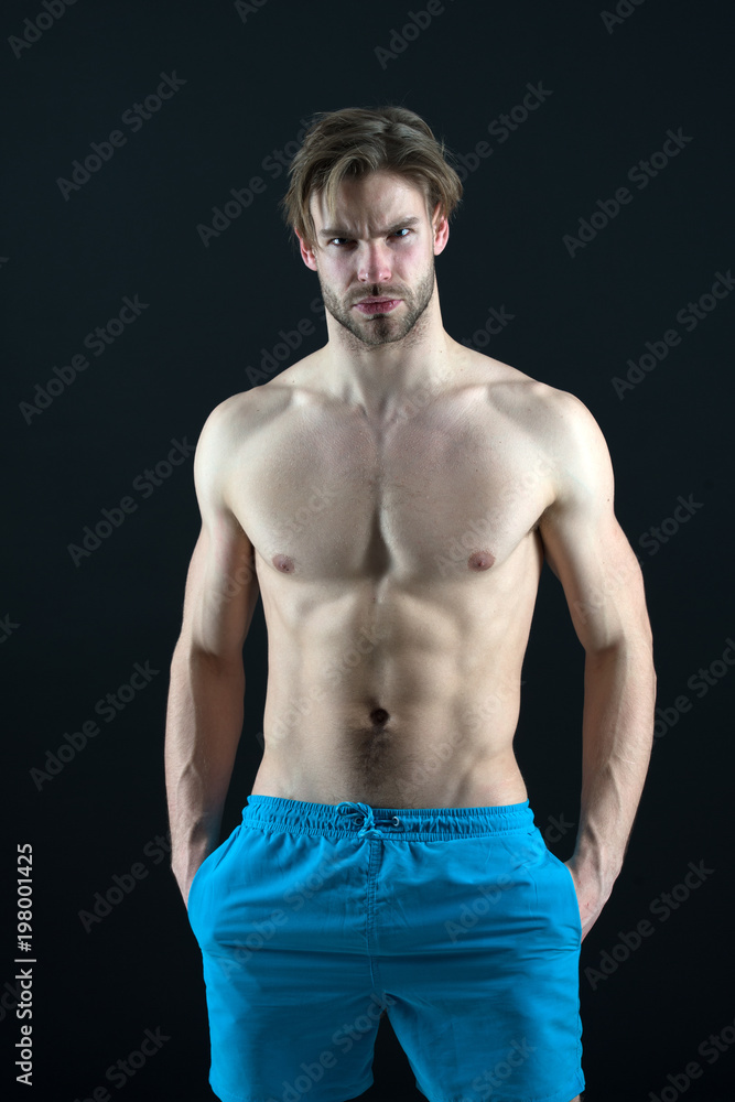 Man athlete show muscular torso in blue shorts, fitness Man athlete show muscular torso in blue shorts, fitness