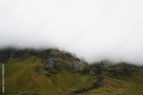 majestic rocky hills covered with green moss in fog  iceland