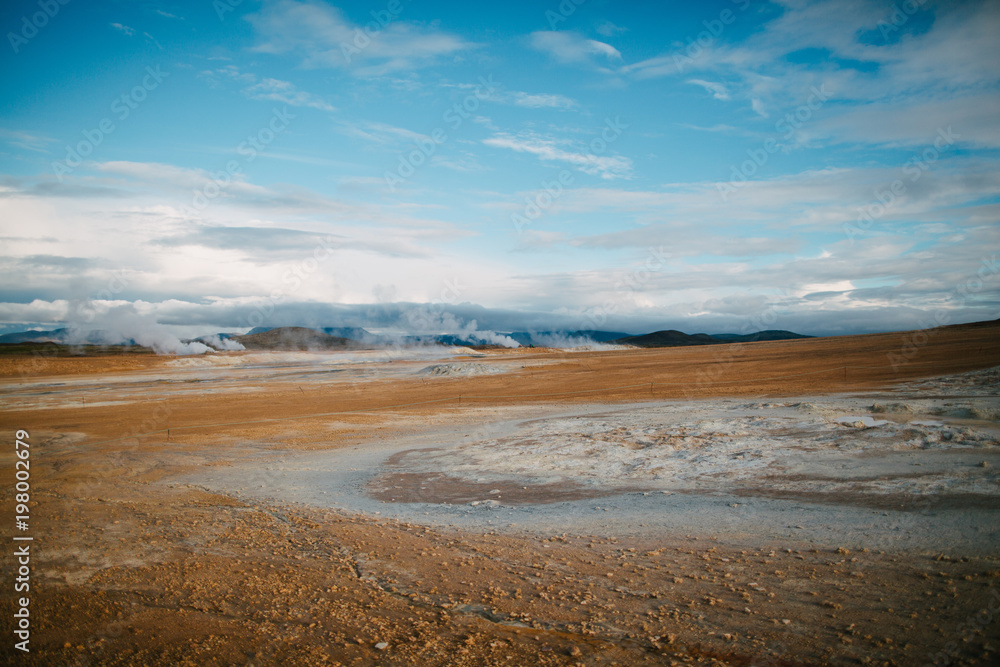 spectacular view of rocky plain and geothermal steam from hot springs in iceland