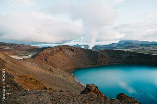 beautiful landscape with scenic volcanic lake viti and steam from hot springs in krafla, iceland
