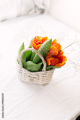 Fototapeta Naklejka Na Ścianę i Meble -  Tulips in a basket on a white wooden background
