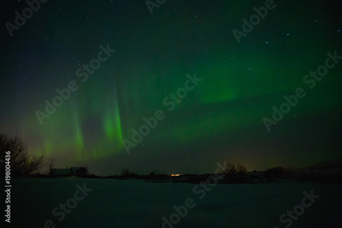 houses under sky with spectacular aurora borealis in iceland © LIGHTFIELD STUDIOS