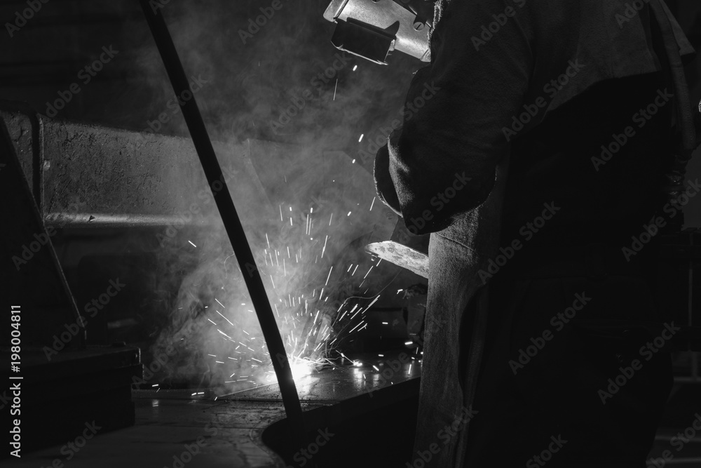 Welder of Metal Welding with sparks and smoke in factory Welder of Metal Welding with sparks and smoke in factory