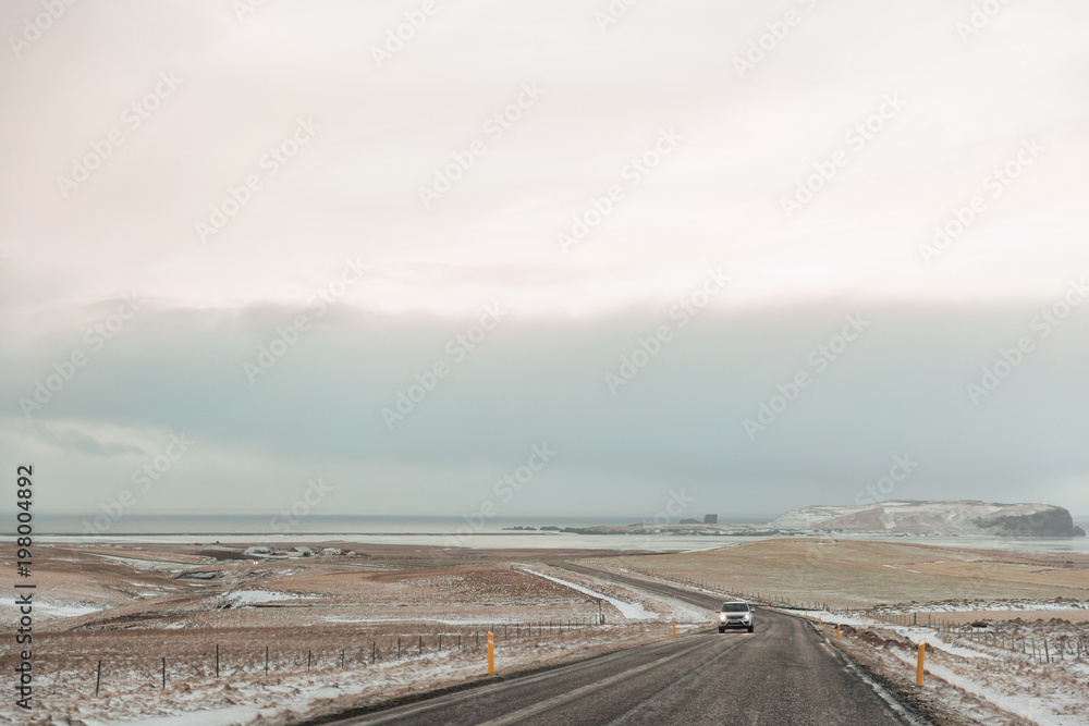 vehicle on road and beautiful snow-covered icelandic landscape