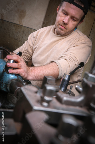 Metal worker working on lathe machine
