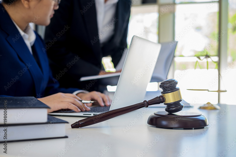 Judge gavel with Justice lawyers having team meeting at law firm in background. Concepts of law. Judge gavel with Justice lawyers having team meeting at law firm in background. Concepts of law.