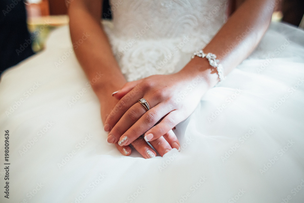 Bride holds her hand crossed on the knees Bride holds her hand crossed on the knees