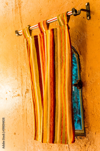 Close up of window curtain hanging against the yellow wall  © GoodPics