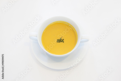 Bowl of pumpkin soup isolated on a white background