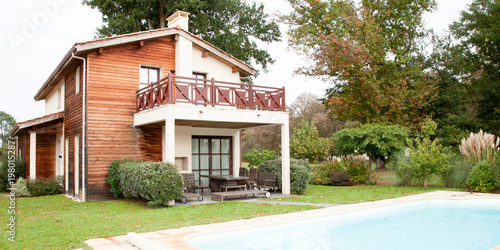 large wood house with private pool for swimming in summer day © OceanProd