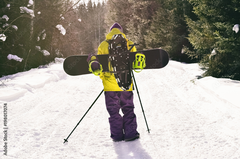 Back view of walking man with snowboard and snowshoes going on backcountry  tour Stock Photo | Adobe Stock