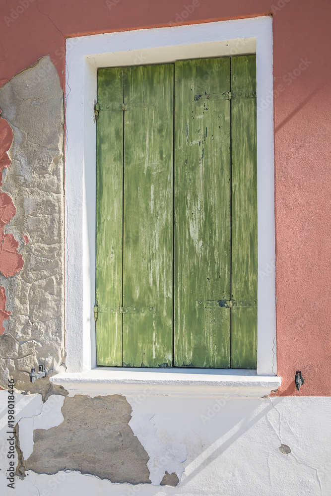 Φωτογραφία close up on an old house facade with aged decrepit green wooden shutter and oran