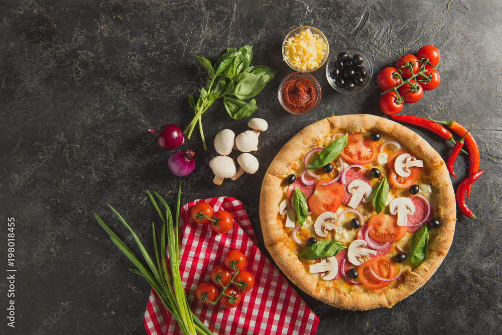 flat lay with italian pizza and fresh ingredients on dark surface flat lay with italian pizza and fresh ingredients on dark surface