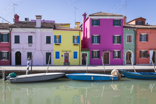 Typical canal with colorful facades with vibrant colors in famous fishermen village on the island of Burano, Venice, Italy