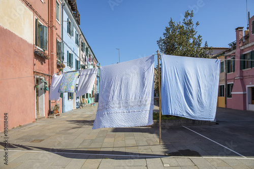 Colorful facades with vibrant colors and laundry drying in famous fishermen village on the island of Burano, Venice, Italy © Melanie