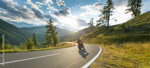 Motorcycle driver riding in Alpine highway, Nockalmstrasse, Austria, Europe. photo