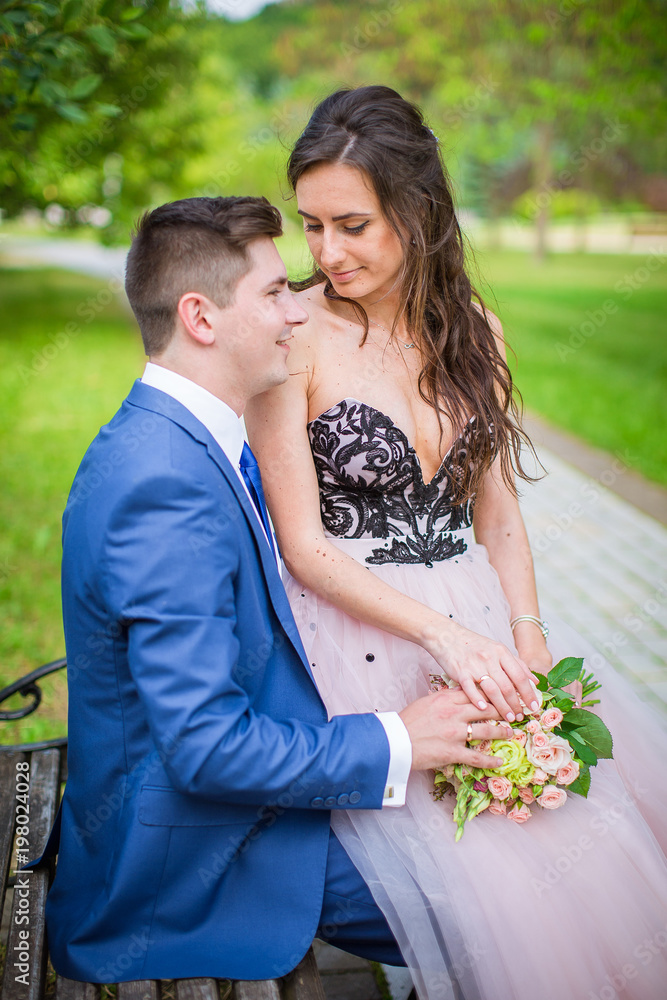 Bride and groom on bench in garden Bride and groom on bench in garden