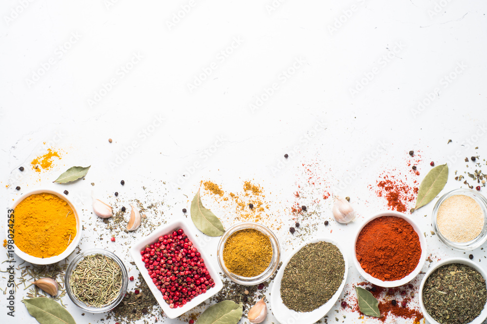 Various spices in a bowls on white.