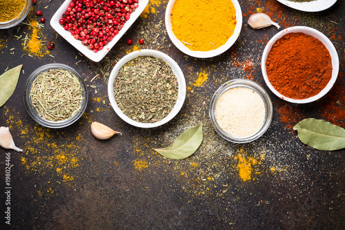 Various spices in a bowls on stone table. © nadianb