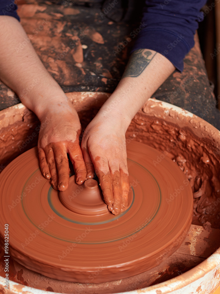 production process of pottery. Forming the clay cover of the kettle on the potter's wheel.